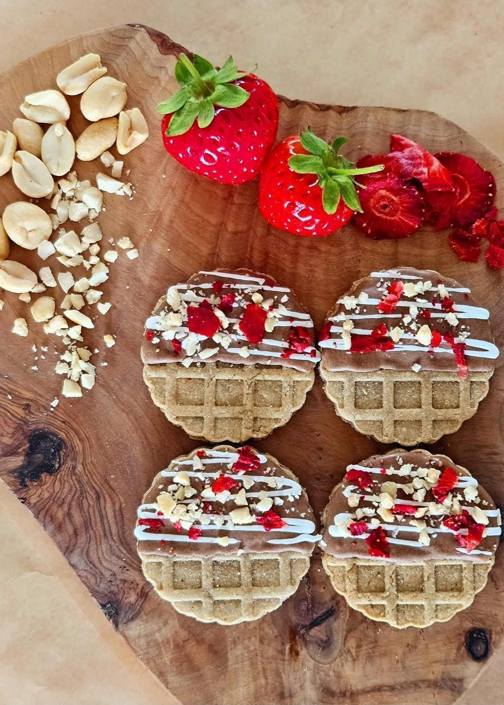 Fun waffle dog biscuits topped with icing, carob, strawberry and peanut sprinkle